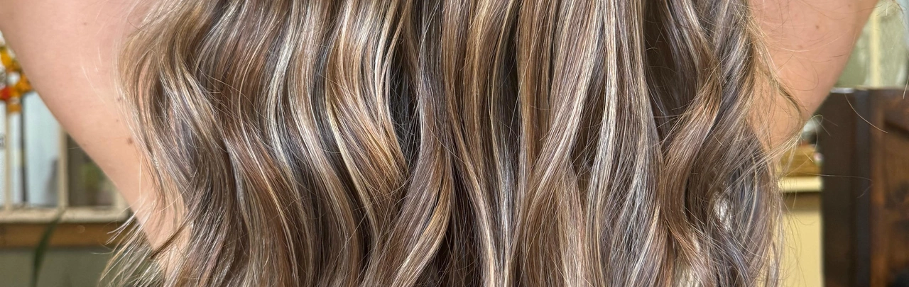 Long softly waved salon hair with dimensional highlights and a polished styled finish