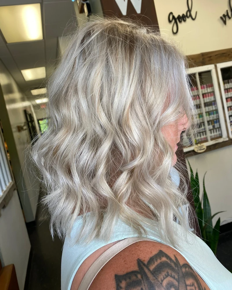 Shoulder-length cool-blonde hair styled in loose waves.