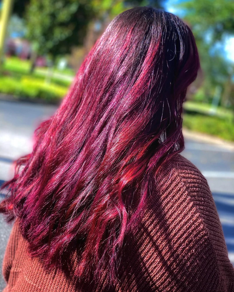 Long berry-colored waves with reflective shine in daylight.