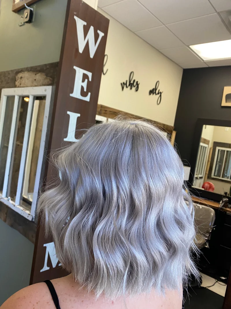 A shoulder-length silver-lilac wavy style.