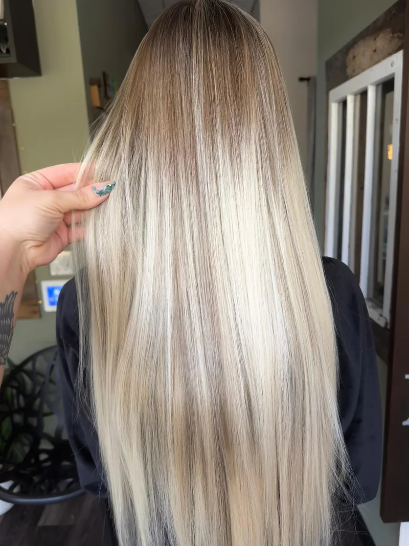 Long straight beige-blonde hair with a darker root gradient.