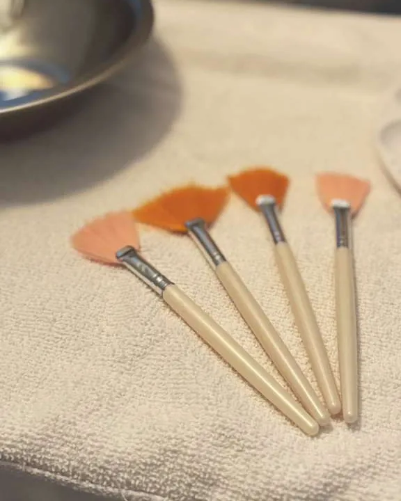 Soft facial brushes arranged on a folded treatment towel