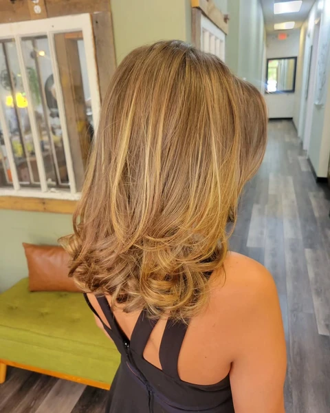 Modern layered blonde haircut with visible shape and softly styled ends