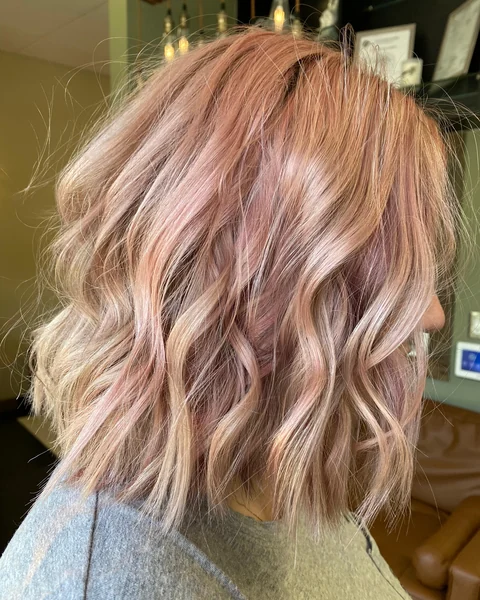 Soft rose-toned lob haircut with polished shoulder-length shape