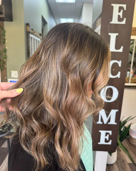 Dimensional brunette salon result with soft polished waves from crown through ends