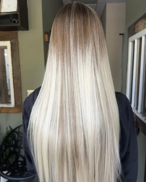 Platinum blonde hair with a sleek glossy salon finish from crown through ends