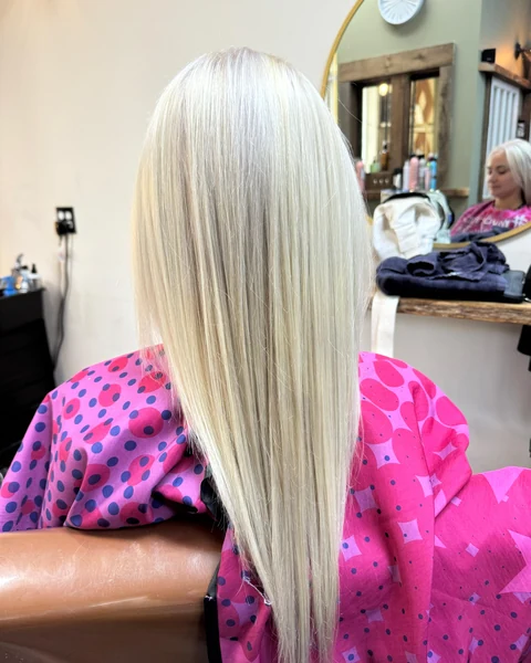Salon client with a bright smooth blonde finish shown from crown through shaped ends