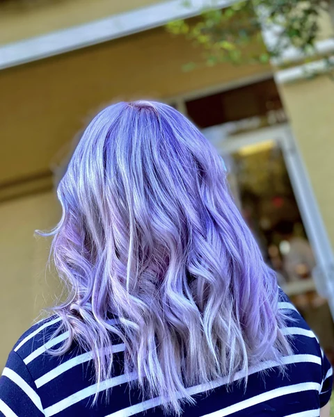 Salon client with dimensional lavender creative color and soft curls