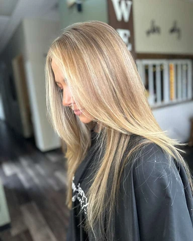 Salon client with a modern layered haircut and polished styled finish from crown through ends