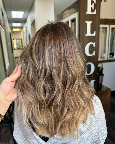 Salon client with dimensional color and polished golden waves