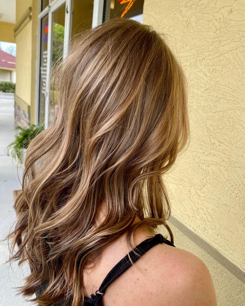 Salon client with a polished brunette shoulder-length cut and styled movement
