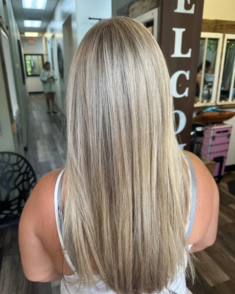 Salon client with bright blonde hair and a sleek luminous finish