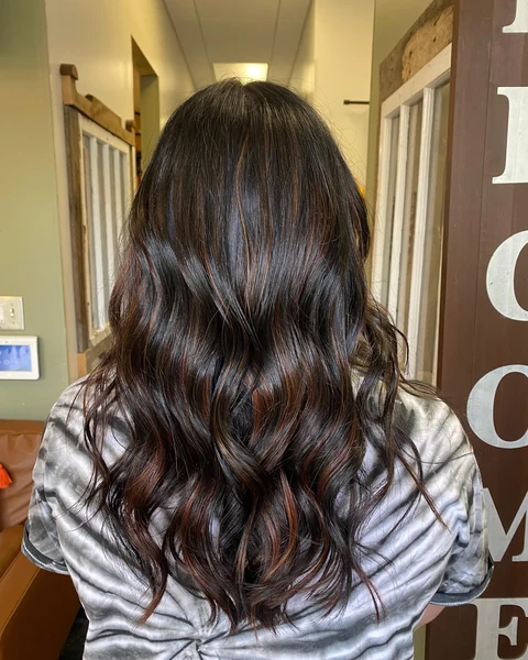 Salon client with glossy dimensional brunette waves and soft movement