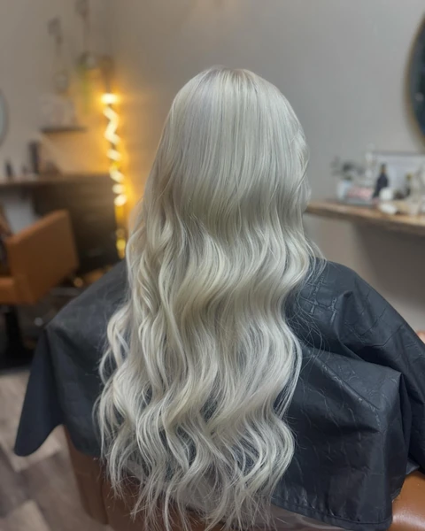 Platinum blonde result styled in soft waves
