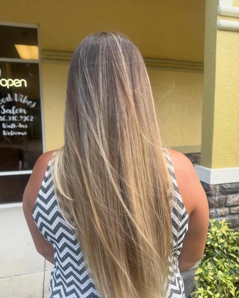 Long dimensional blonde salon result photographed from the back